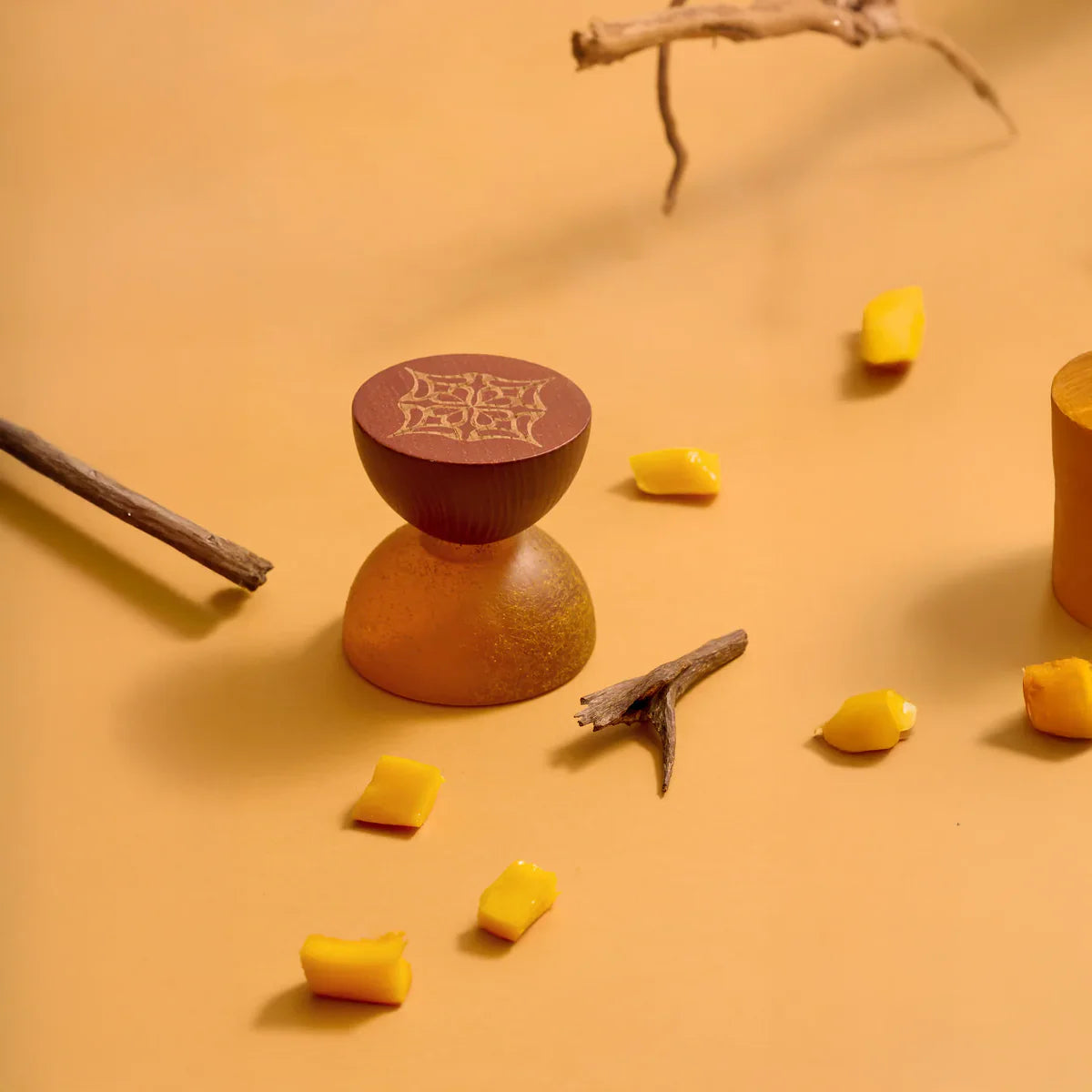 Mango Oud by LOVA perfume bottle styled with mango slices and wood on orange background