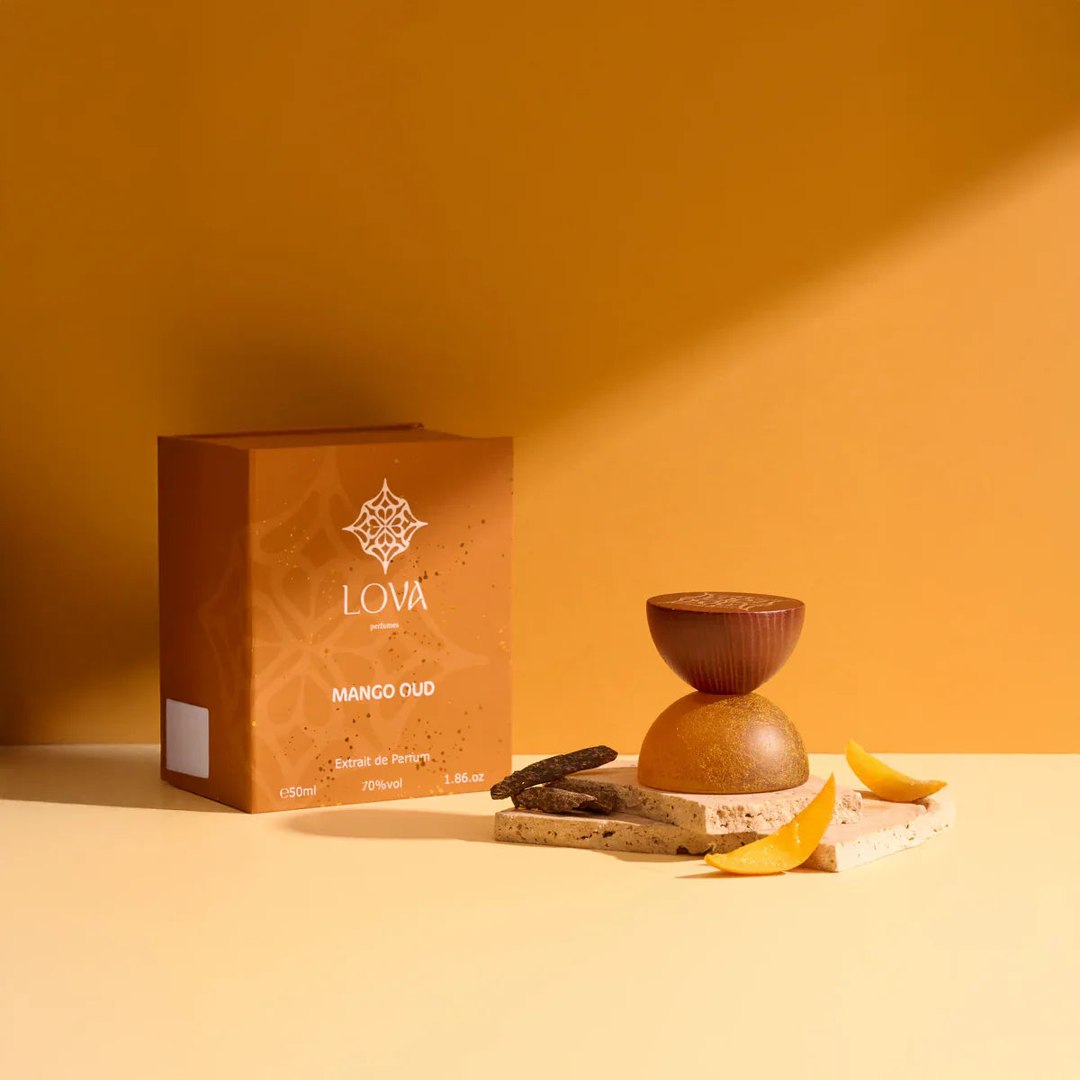 Mango Oud by LOVA perfume bottle and box with mango pieces on warm orange background