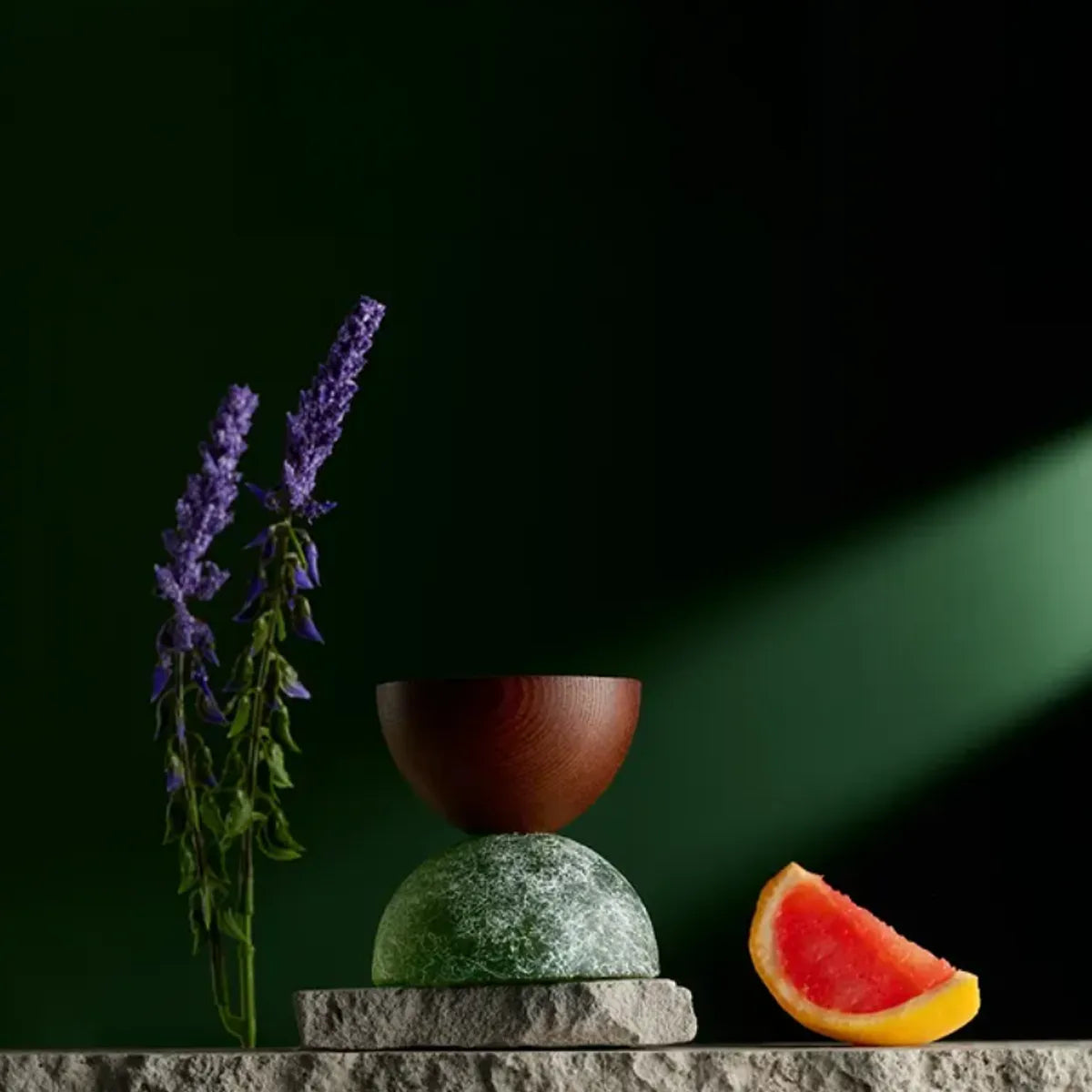 Decorative arrangement with a vase, flowers, and a watermelon slice on a dark background