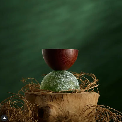 Wooden bowl on a textured surface with a green background