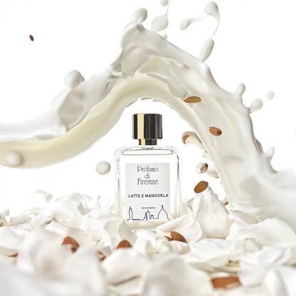 Perfume bottle labeled 'Profumo di Firenze' surrounded by a splash of milk and almonds on a white background